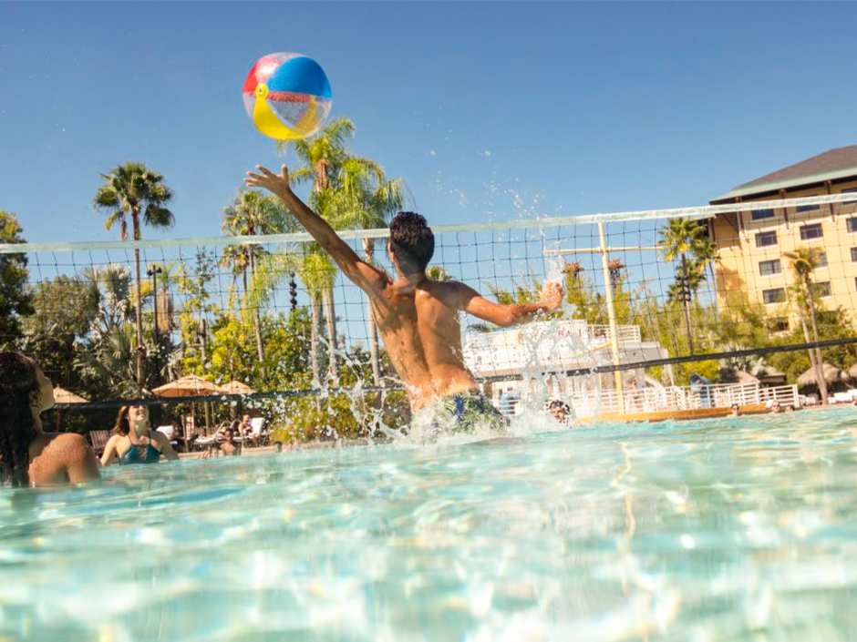 Friends playing volleyball at Loews Royal Pacific Resort.