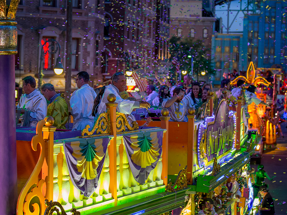 Guests throw beads at the crowd from atop a Mardi Gras float