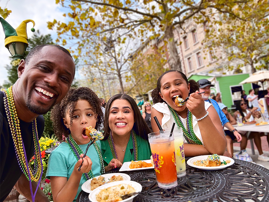 A family enjoys Mardi Gras food and drinks together