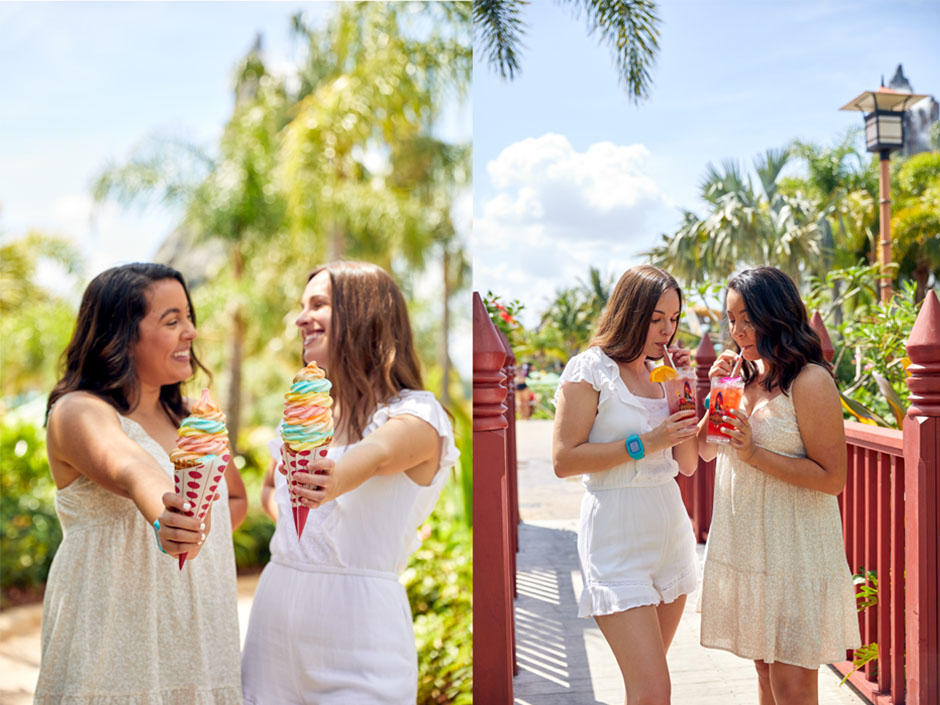 A collage of two images of the same two women, with ice cream on the left and drinks on the right. In the image on the left, the woman on the right is wearing a light beige, spaghetti-strap dress and a blue TapuTapu band on her right wrist, smiling toward the woman on her left, who is wearing a white romper and smiling back at the other woman. They each hold rainbow ice cream in cones, which are wrapped in white paper with red polka dots. They stand in front of blurred trees, and a blue sky. In the image on the right, the two women switch sides. A blue TapuTapu band is visible on the other woman's right wrist. They are drinking pink bevarages out of glasses with white straws on a red bridge with a light brown, wooden floor. The glass on the left has an orange on the rim. They stand in front of blurred trees and a blue sky with clouds.