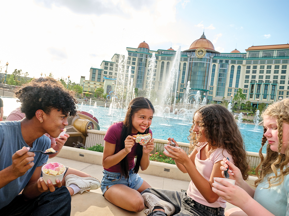A group of young teens eating ice cream in front of Helios Grand Hotel