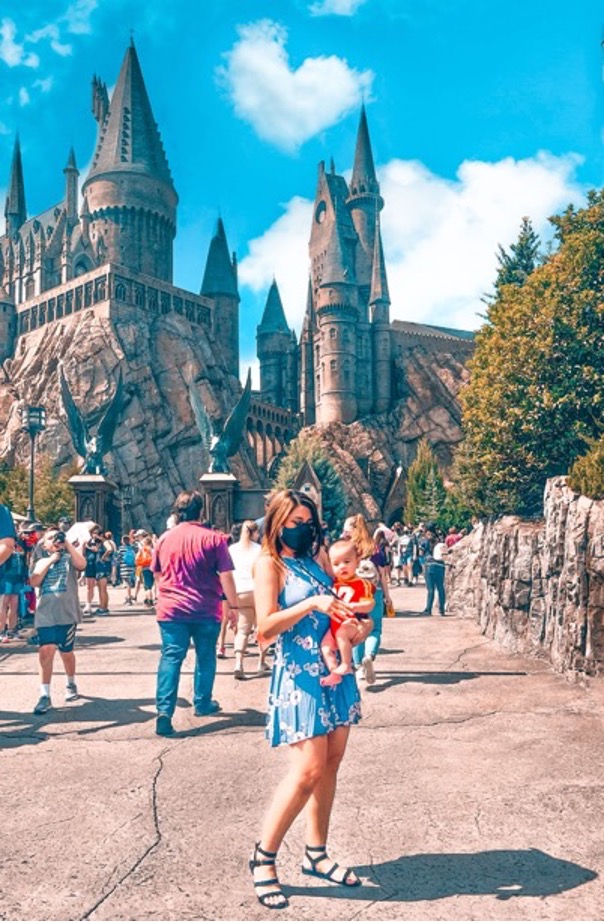 A woman and baby in front of Hogwarts Castle 