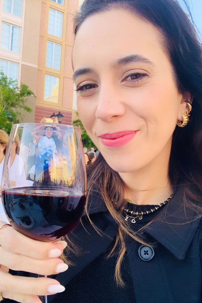 Andrezza holding glass of red wine at Harbor Nights at Portofino Bay Hotel