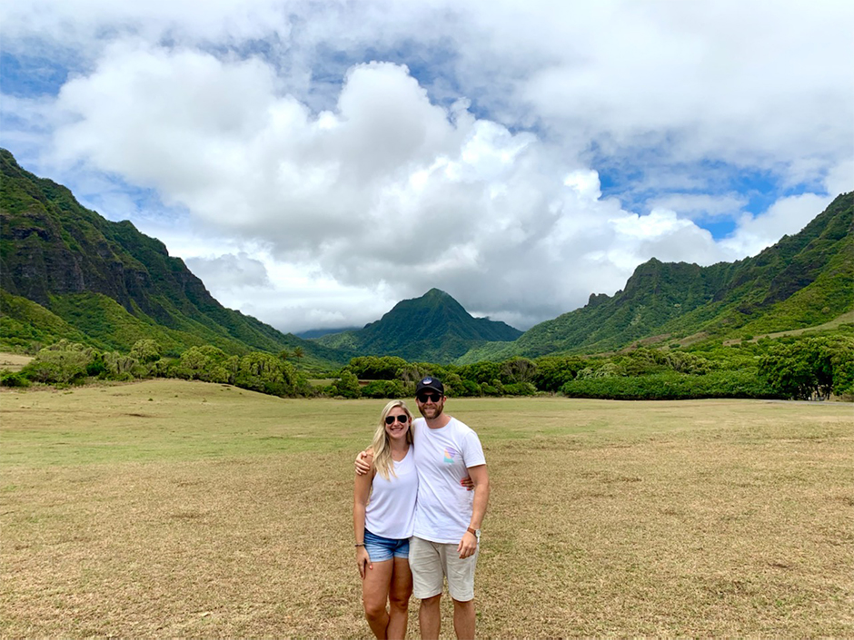 Couple in Hawaii with mountains and clouds