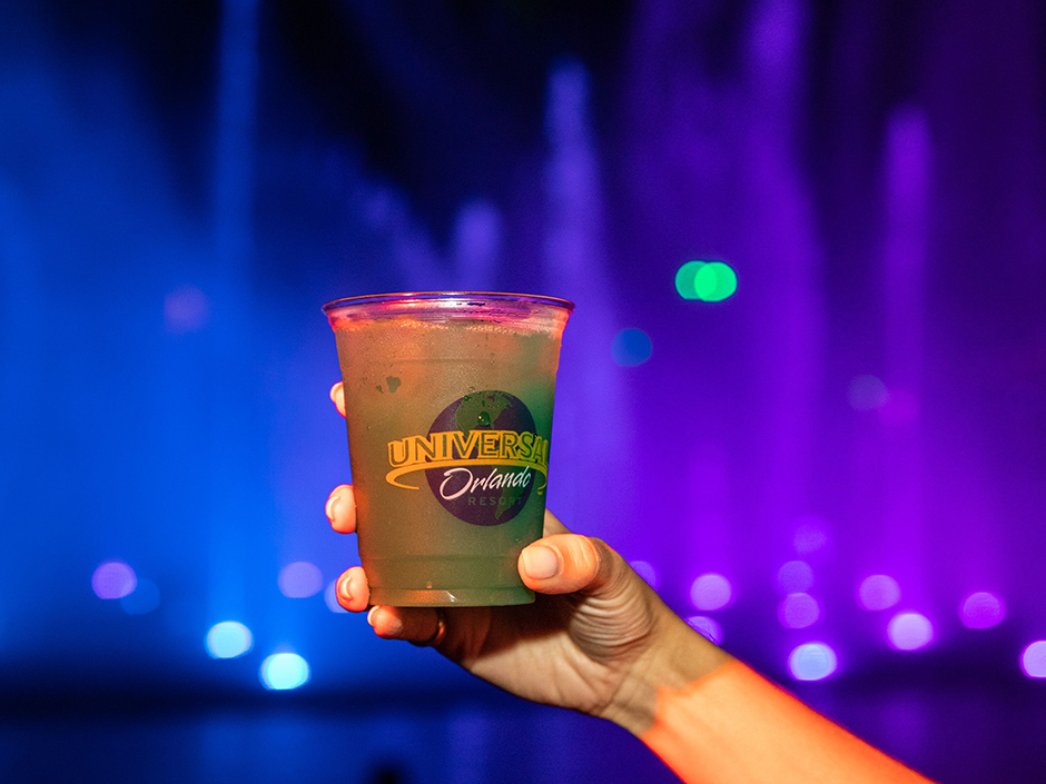 Hand holding Electric Death Cocktail with Ghoulash Show in Background HHN31