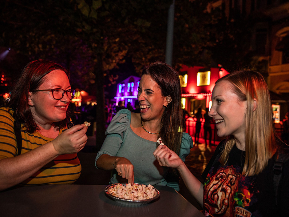 Three women eating sweet kettle corn popcorn during HHN31