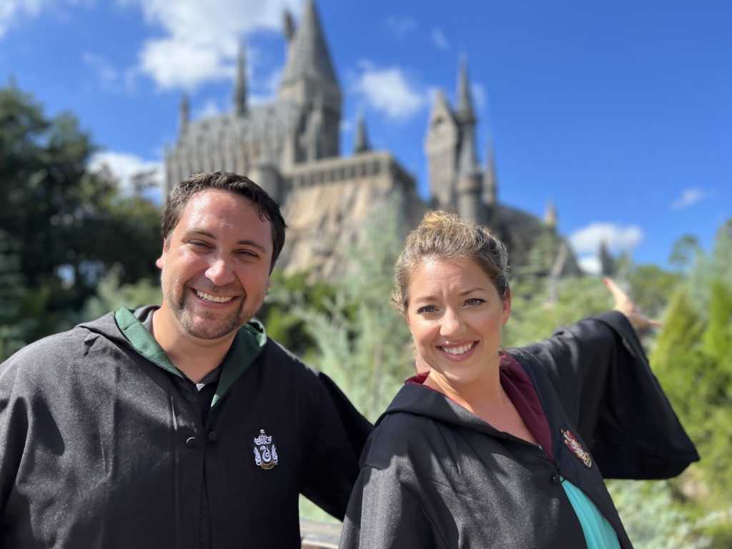 Kari and David pose in front of the Hogwarts Castle in Islands of Adventure.