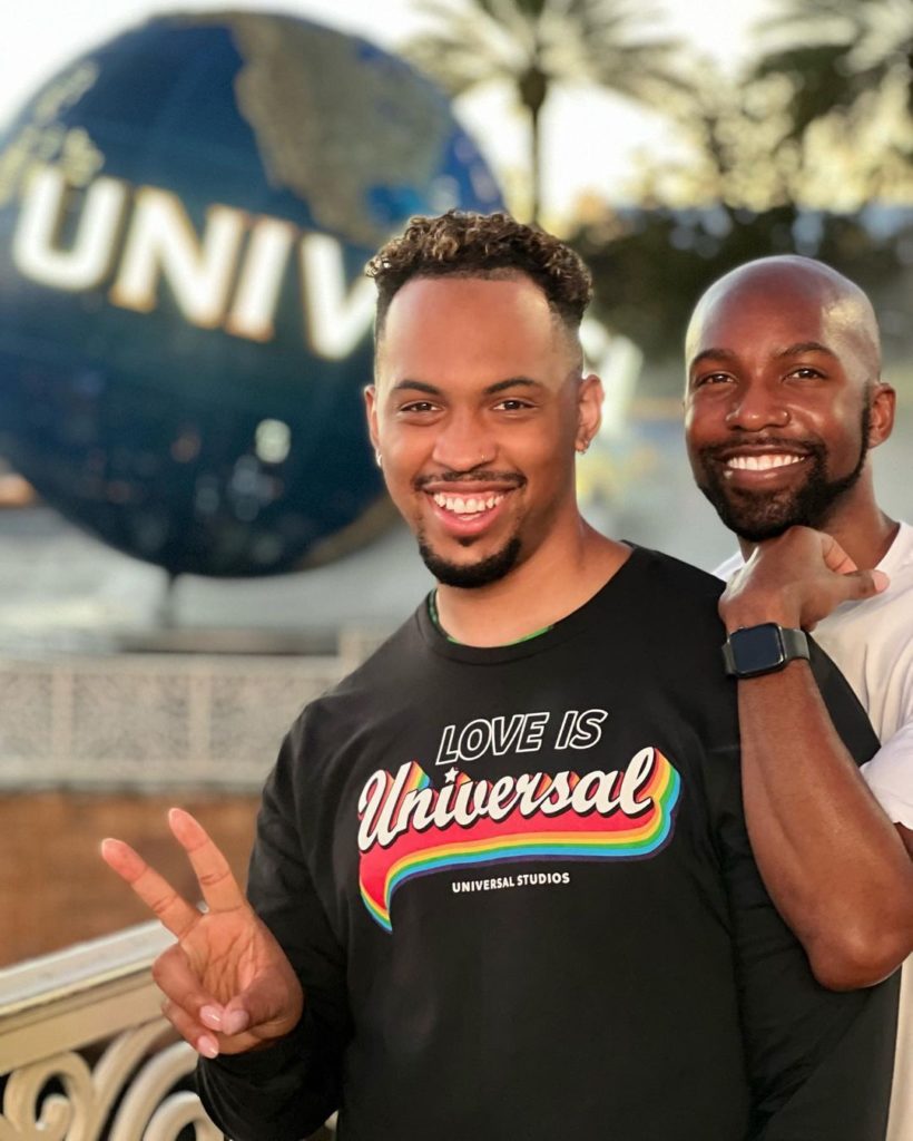 Two people standing in front of Universal globe