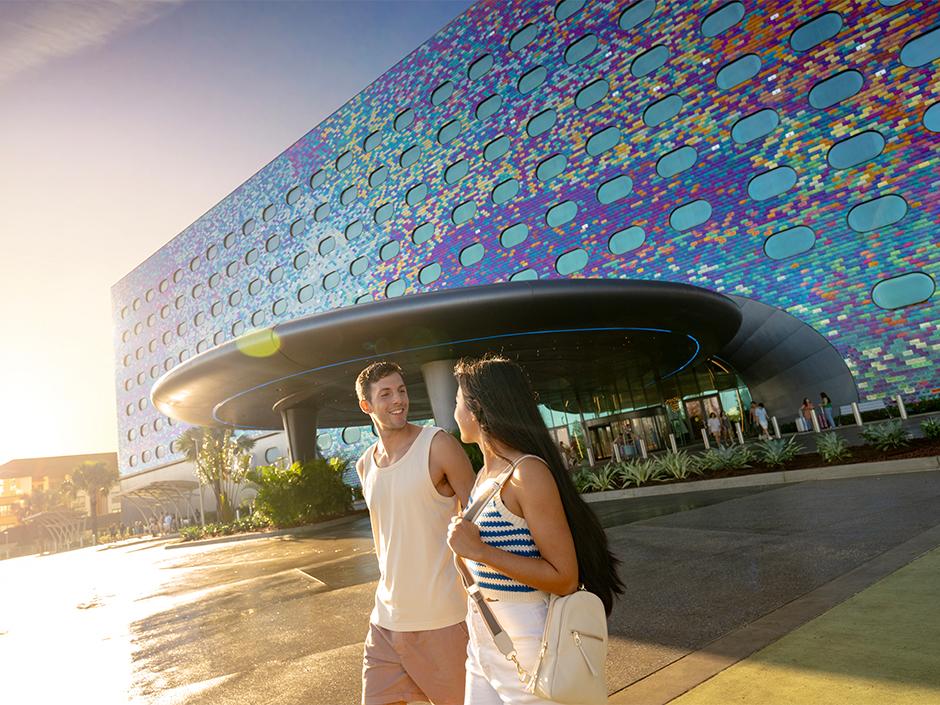A couple smiles and walks together outside of Universal Stella Nova Resort