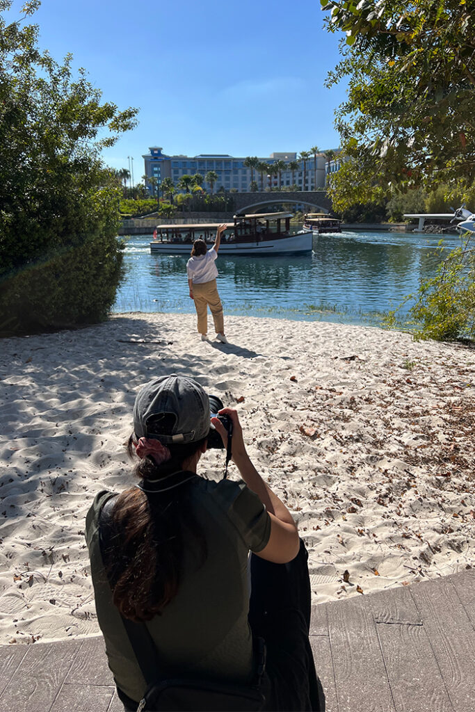 Woman standing in sand in front of Water Taxi at Universal Orlando