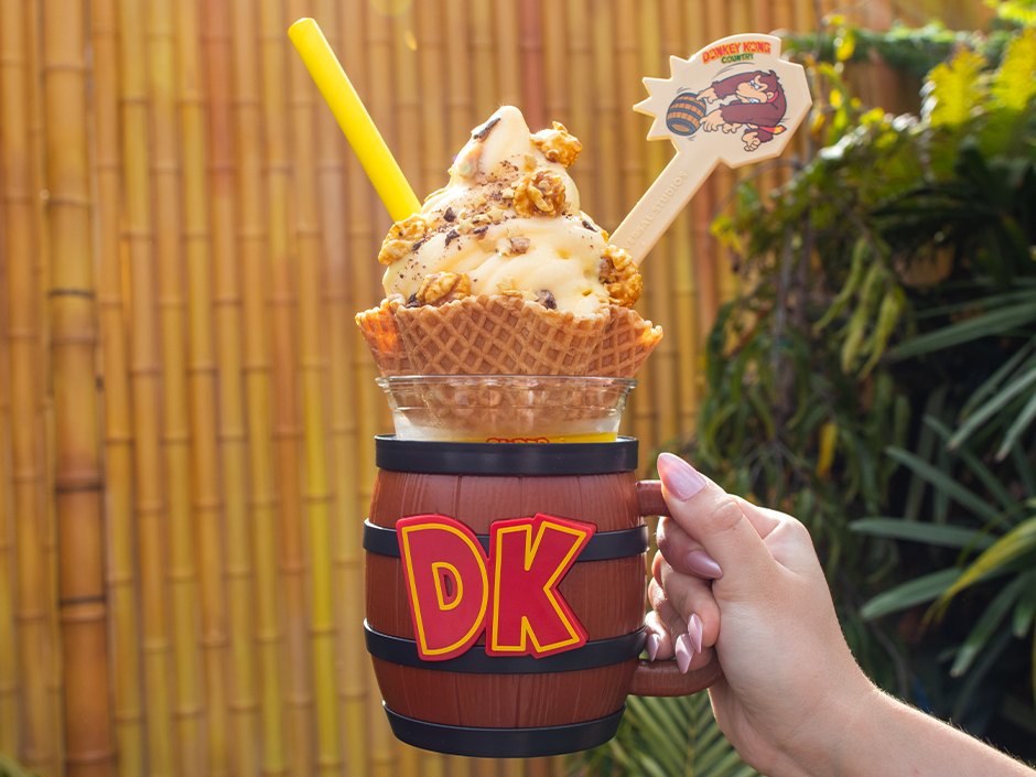 A hand holding up a DK Crush Float in SUPER NINTENDO WORLD at Epic Universe