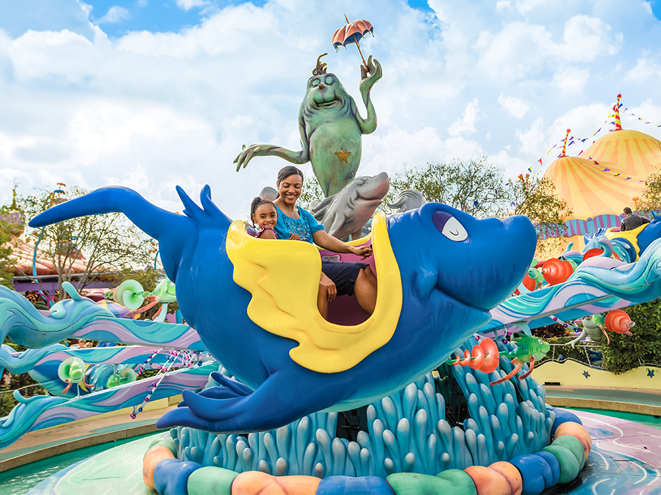 A mother and daughter smile at each other while riding One Fish Two Fish at Universal Islands of Adventure