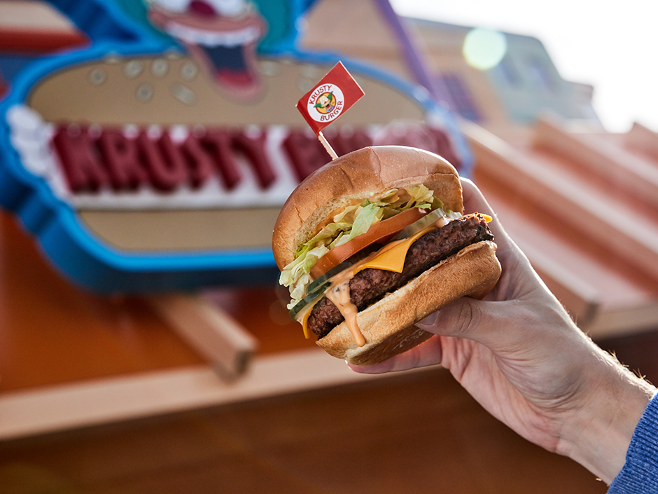 A cheeseburger in front of the Krusty Burger sign, among the many foods available at Universal Studios Hollywood. 