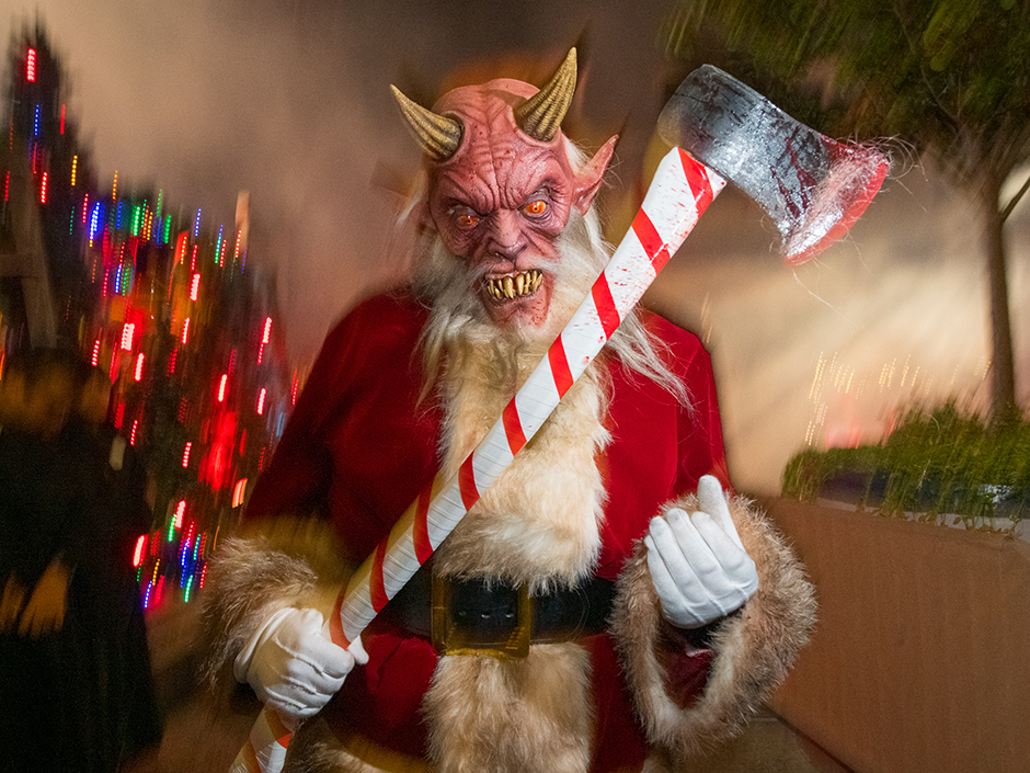Satan in a Santa Claus outfit holds axe