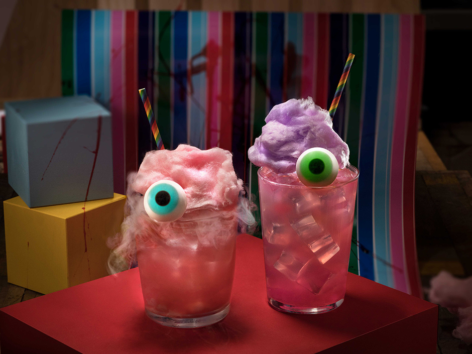 Two Chucky-themed cocktails, which are pink and topped with gummy eyeballs.