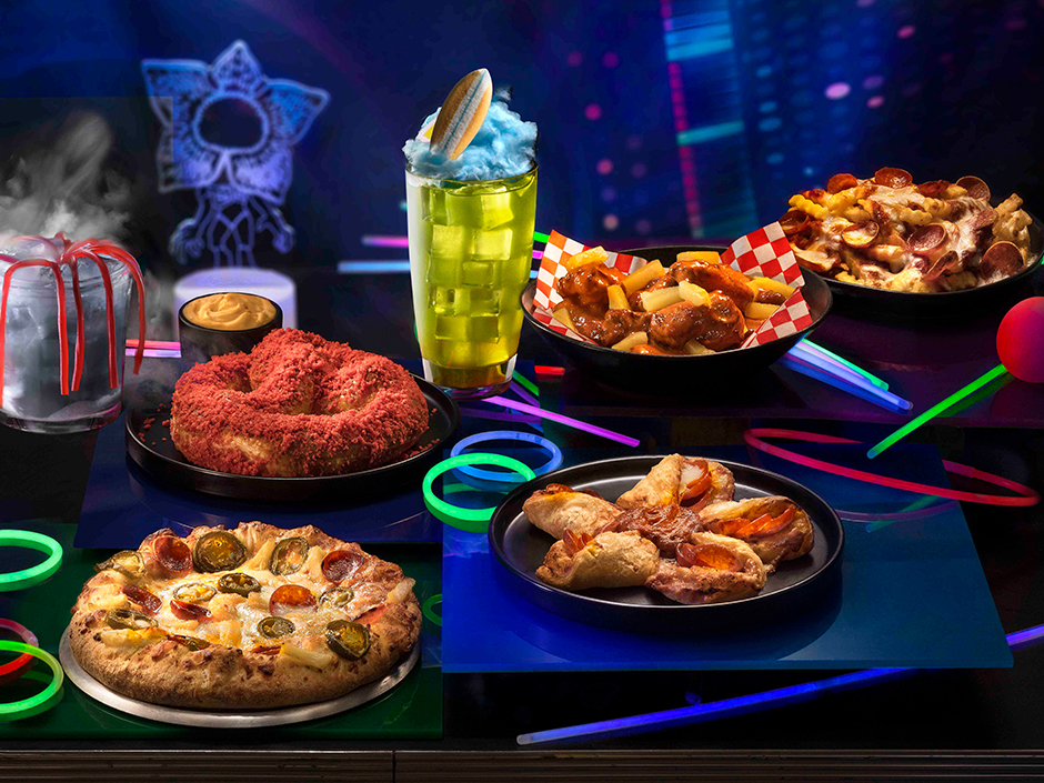 Halloween Horror Nights offerings based on Stranger Things, including pizzas and a yellow cocktail with a candy surfboard on it.