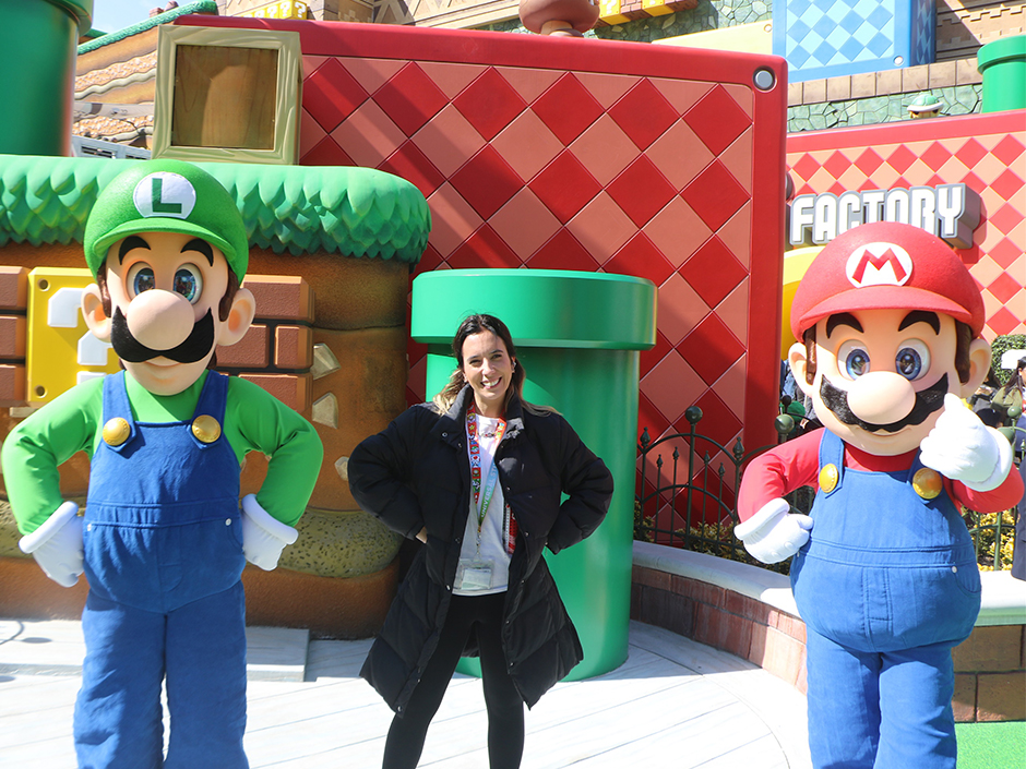 A woman poses with Mario and Luigi meet-and-greet characters at SUPER NINTENDO WORLD. 