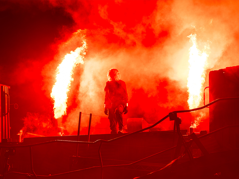 Flames erupt on each side of a performer at The Purge: Dangerous Waters