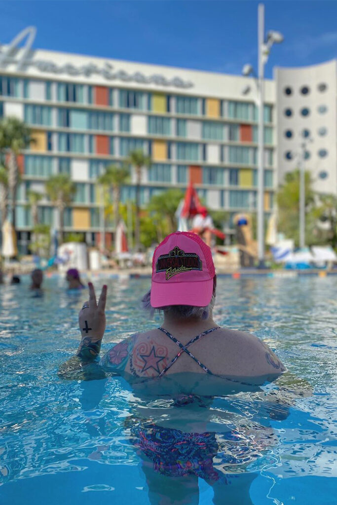 A person in a pink hat in a hotel pool
