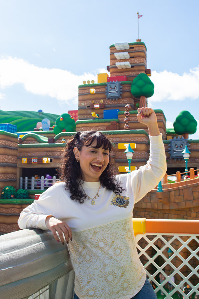 A guest posts with their fist up in the "Power-Up" pose in SUPER NINTENDO WORLD at Universal Epic Universe