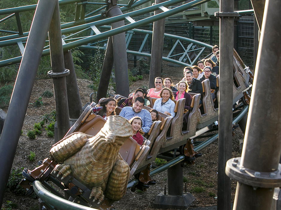 A group of people smiling and riding the Flight of the Hippogriff.