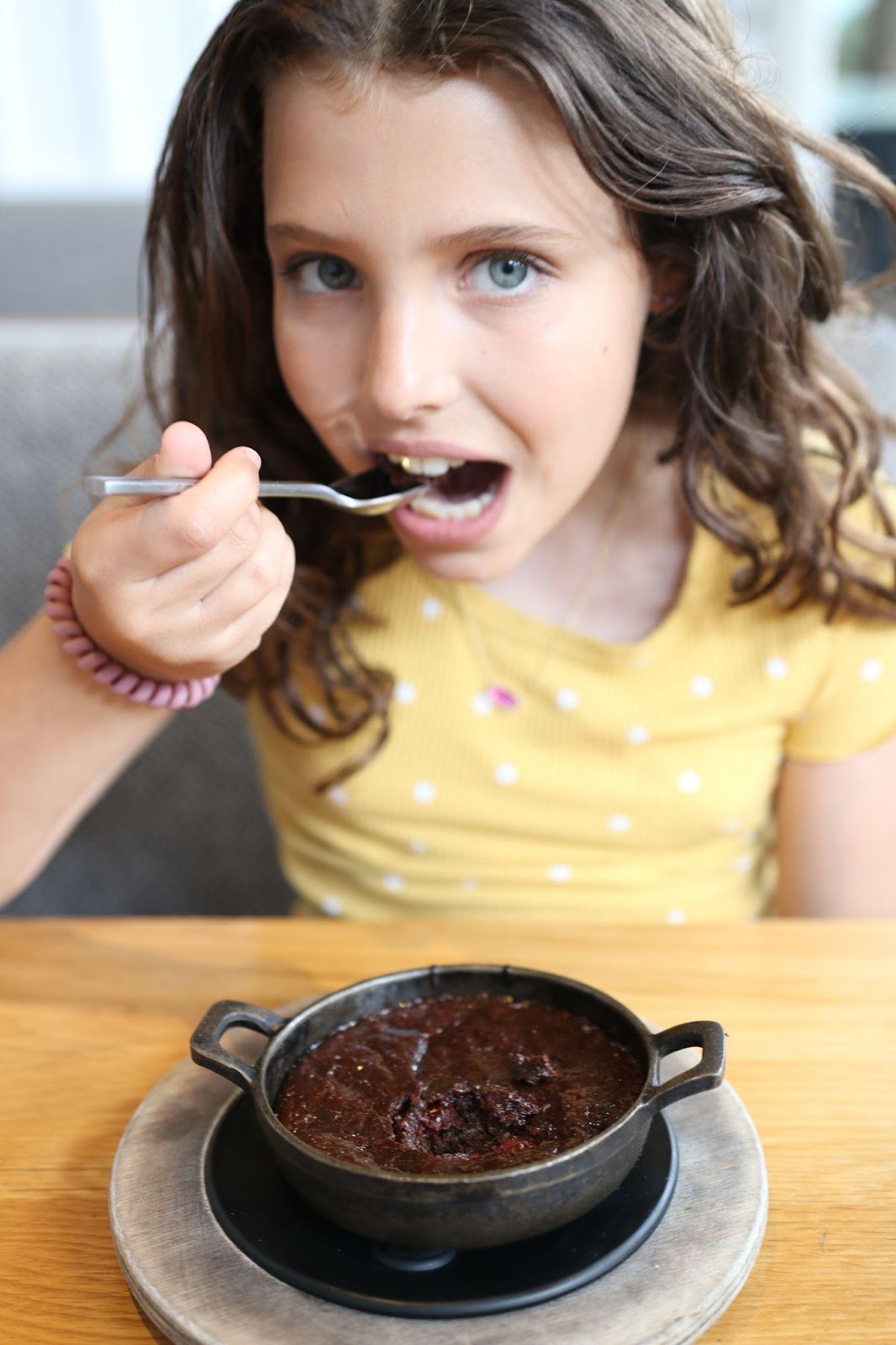 A girl eats a chocolate dessert