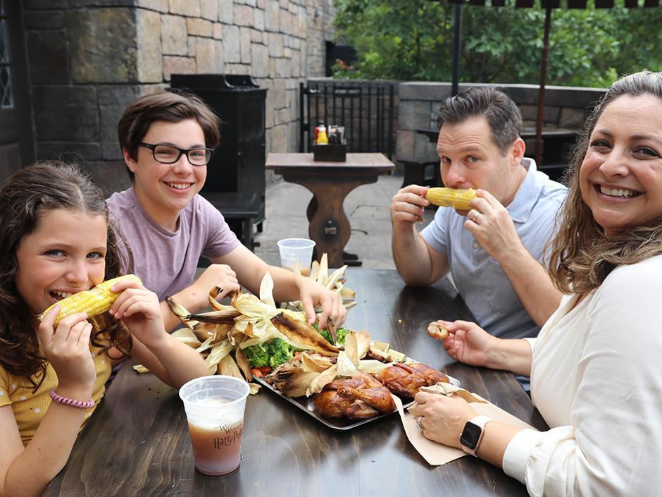 A family enjoying The Great Feast from Three Broomsticks