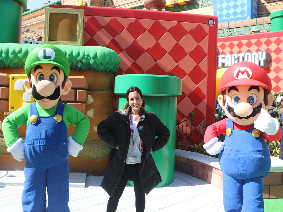 A woman posing with Mario and Luigi at SUPER NINTENDO WORLD. 