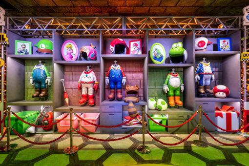 The queue of Mario Kart: Bowser's Challenge. Different costumes line the wall.