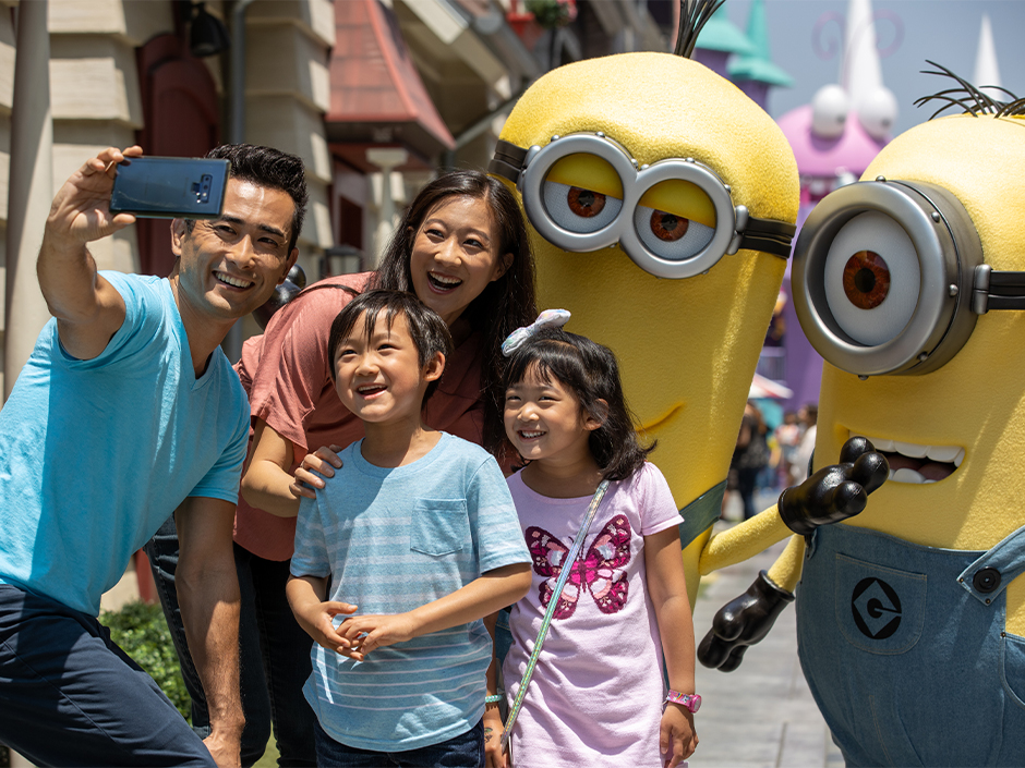 A family of four poses with two Minions.