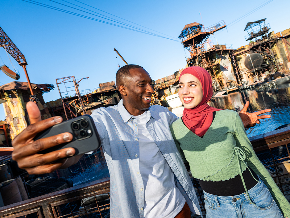 A man and woman looking at each other smiling while taking a selfie.