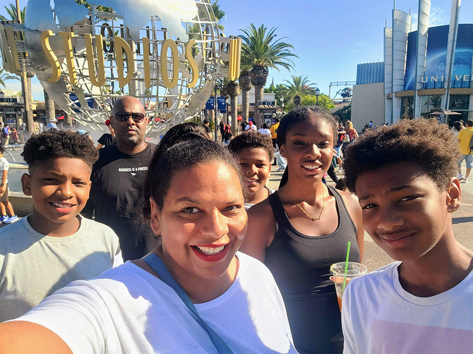 A family posing for a selfie in front of the Universal Studios globe.