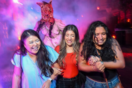 Three girls walk in the fog at Halloween Horror Nights