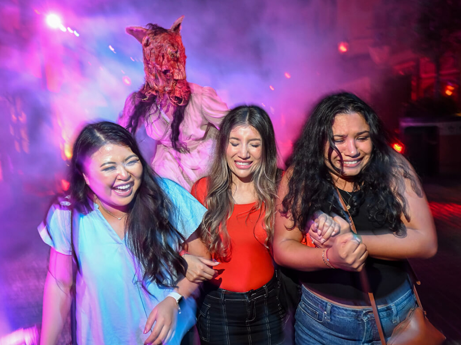 Three girls walk in the fog at Halloween Horror Nights