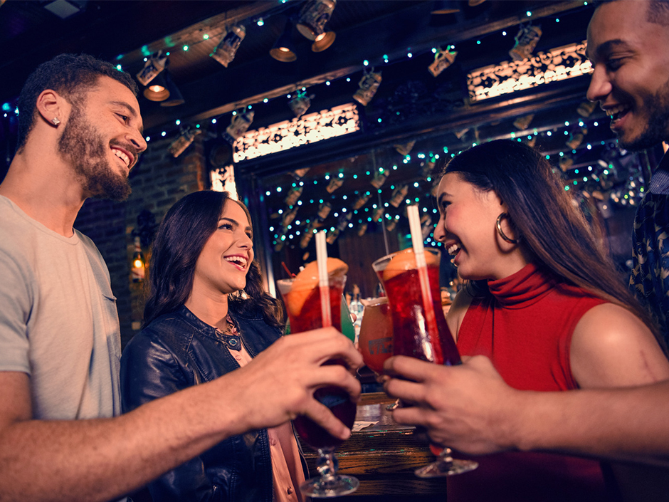 A group of friends smiling and holding drinks.