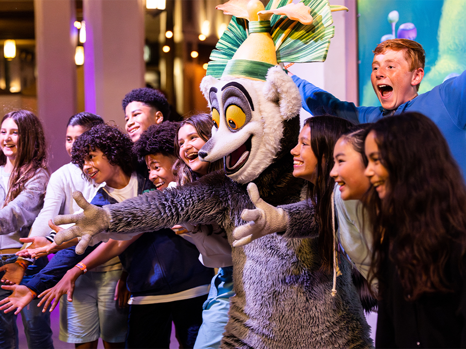 A group of kids smile with King Julien from Madagascar at Universal Studios Hollywood.