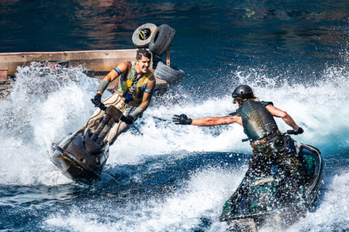 Two men on jet skis perform a stunt at the Waterworld show at Universal Studios Hollywood.