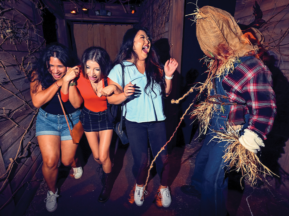 Three girls react to a scare actor in a haunted house at HHN