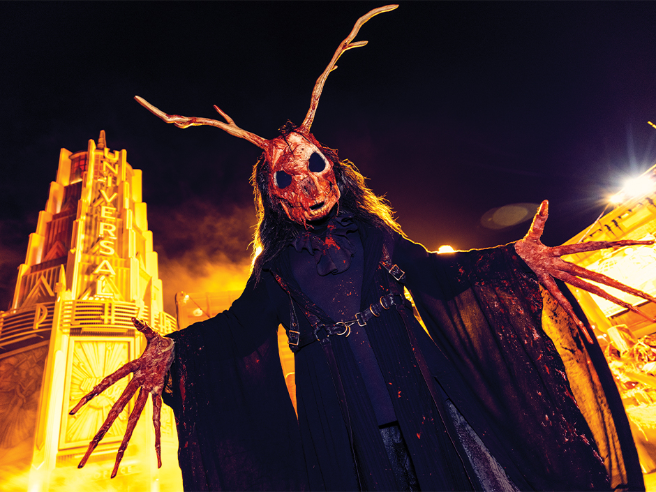 A terrifying creature with antlers in front of the Universal Tower at Halloween Horror Nights.