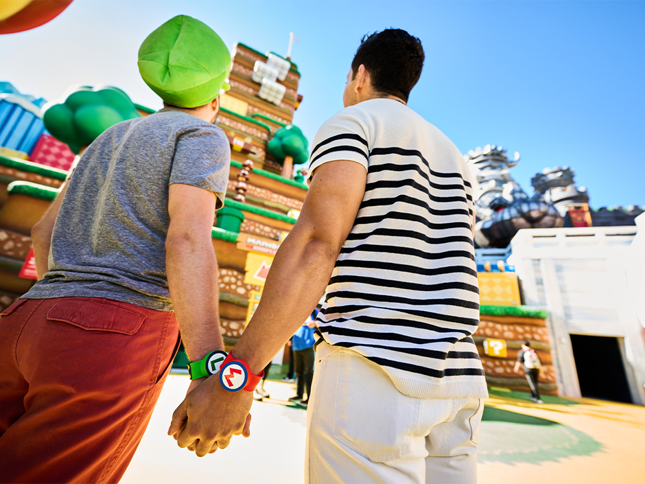 Two guests hold hands at SUPER NINTENDO WORLD.