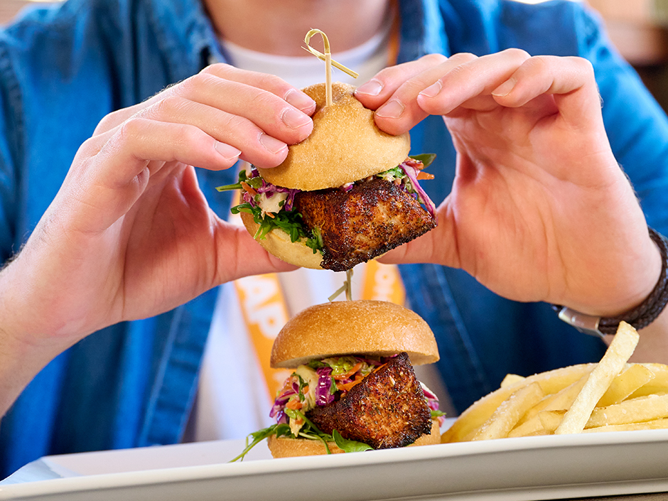 A guest eating salmon sliders from Confisco