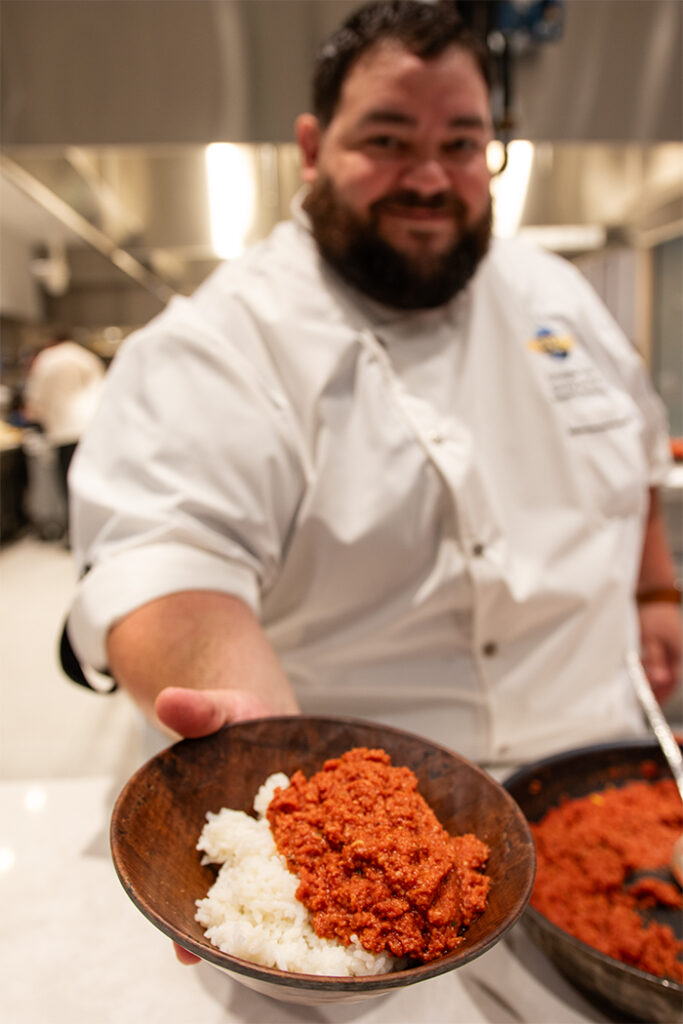 Chef Chris holding his family recipe of corned beef and rice