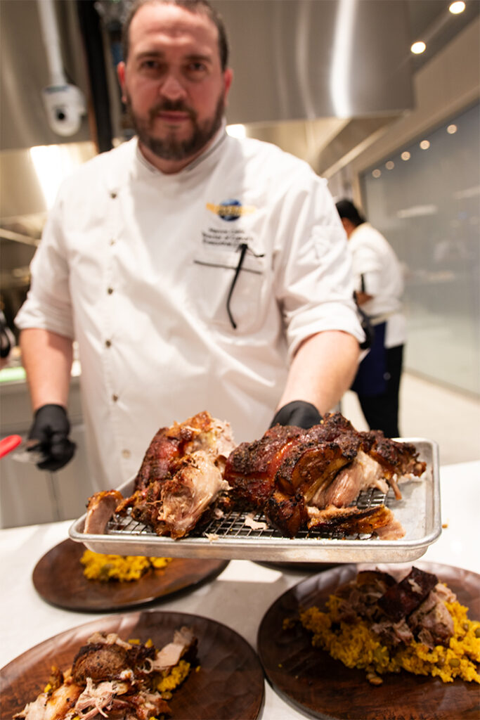 Chef Marcos holding his family recipe of pernil and arroz con gandules