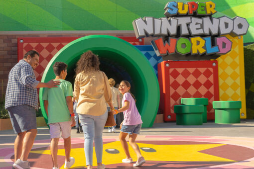 A family enters the green pipe to enter SUPER NINTENDO WORLD.