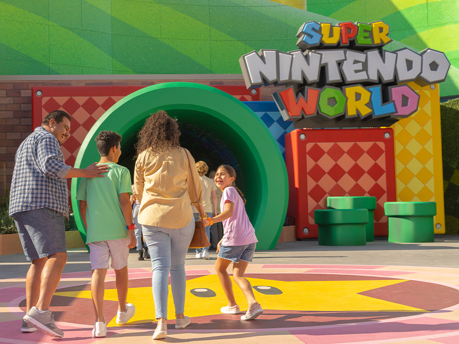 A family enters the green pipe to enter SUPER NINTENDO WORLD.