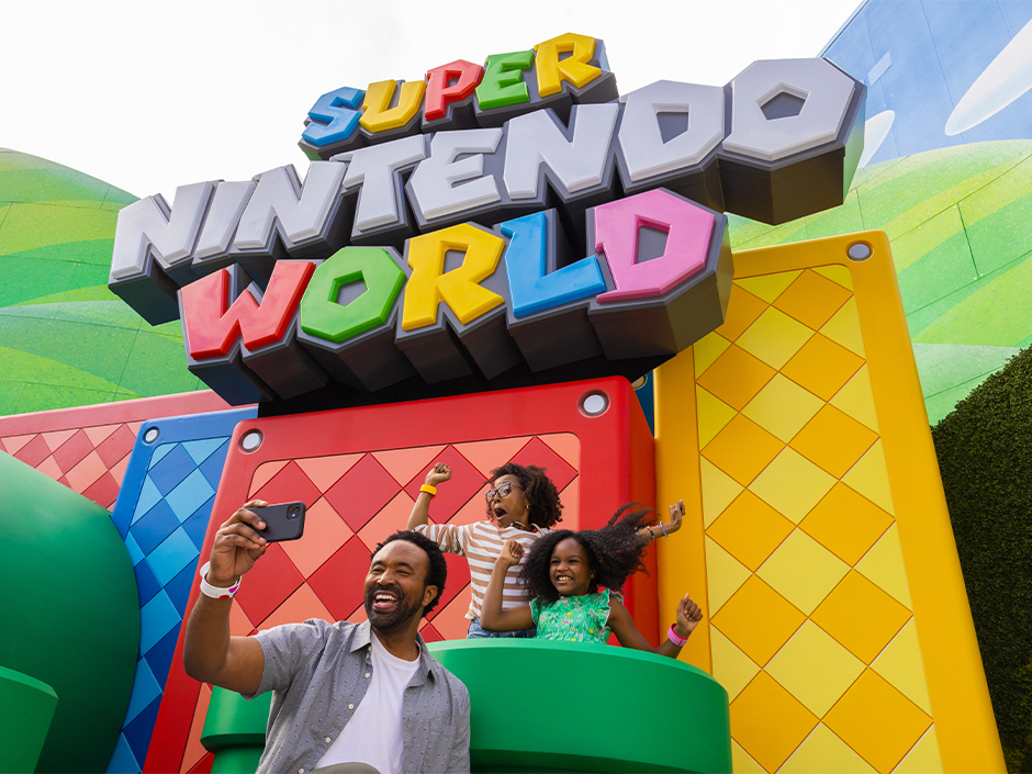 A family poses for a selfie in the green pipes at SUPER NINTENDO WORLD.