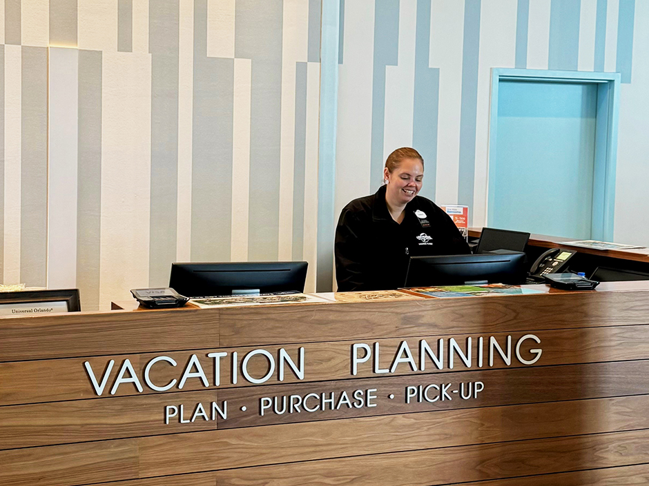 A team member working at a Vacation Planning Desk in a Universal hotel