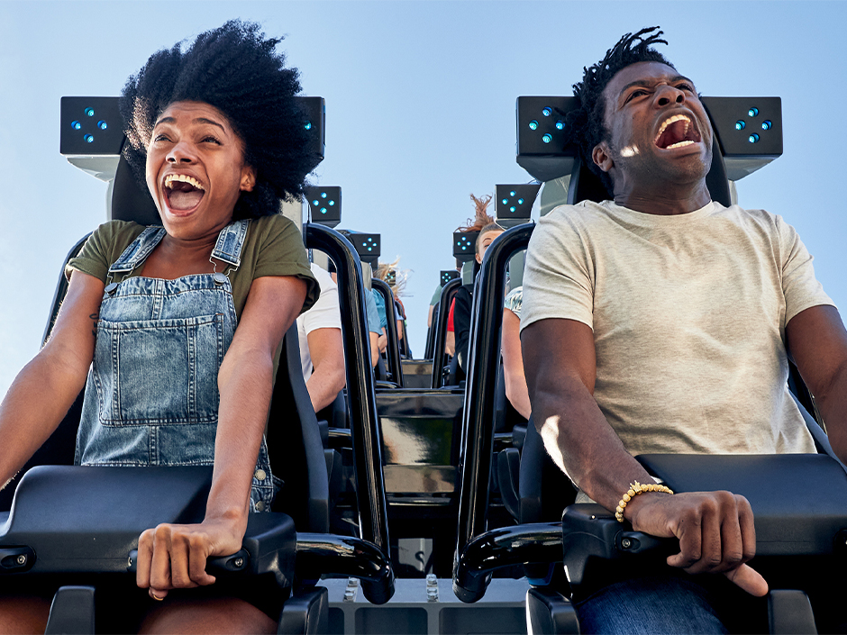 A man and woman scream in delight on Jurassic World Velocicoaster