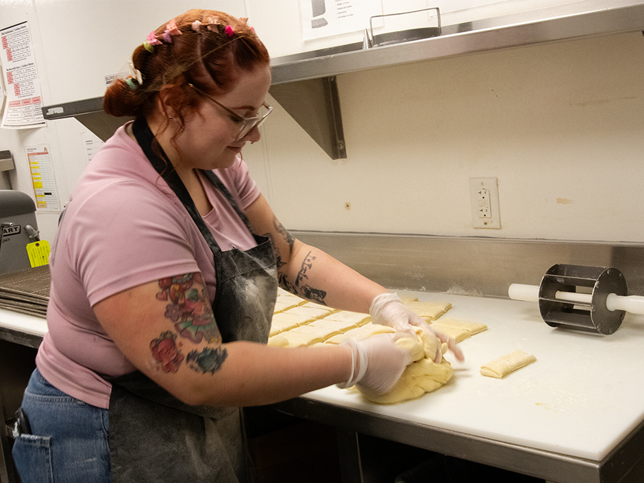 A team member shapes the dough at Voodoo Doughnut