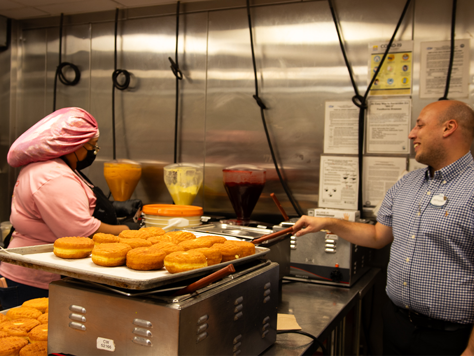 Team members chat while working at Voodoo Doughnut in Universal CityWalk